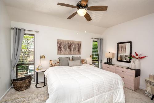 a white bedroom with a bed and a ceiling fan at Lae Nani 434 in Kapaa