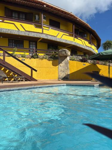 a swimming pool in front of a building at Atobás in Arraial do Cabo