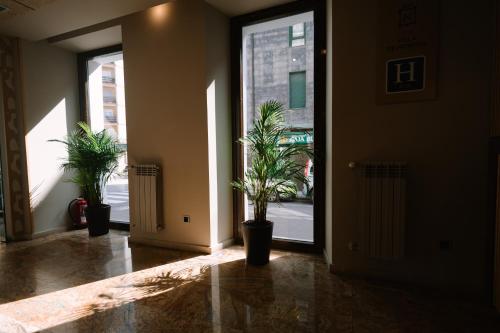 a hallway with two potted plants in a building at Hotel Boutique Villa de Noreña in Noreña
