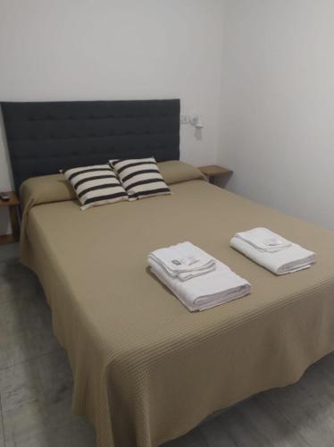 a bed with two towels on top of it at El Tata in Recreo