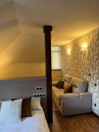 a bedroom with a bed and a couch at Hotel Boutique Villa de Noreña in Noreña