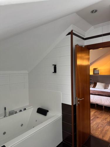 a bathroom with a bath tub next to a bedroom at Hotel Boutique Villa de Noreña in Noreña