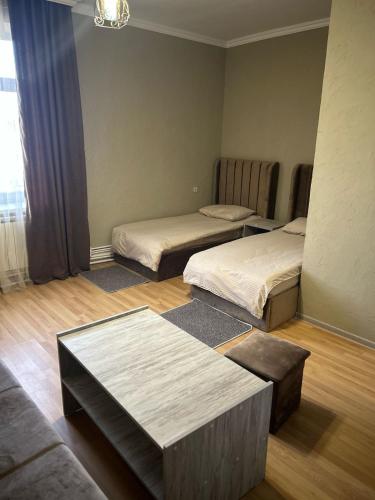 a room with two beds and a table in it at Цар in Martuni