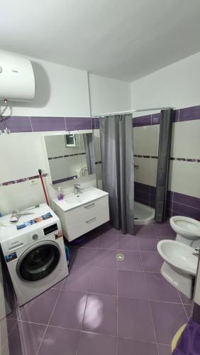 ein Badezimmer mit Waschmaschine und Waschbecken in der Unterkunft Daniel Apartment 2 in Sarandë