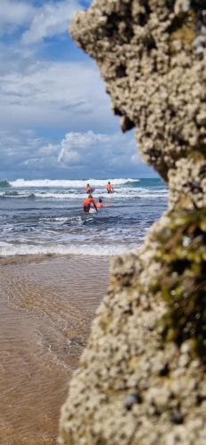two people are in the water at the beach at Imsouane petitsurfer SurfCamp in Imsouane