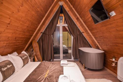 a room with a bed and a window and a tub at Bujtina Miqesia in Theth