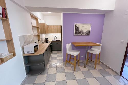 a small kitchen with a table and a purple wall at Penzion Staré Louny in Louny