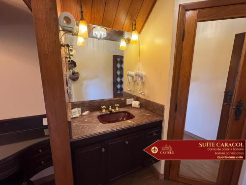 a bathroom with a sink and a mirror at Hotel Castelo Nacional Inn Campos do Jordão in Campos do Jordão