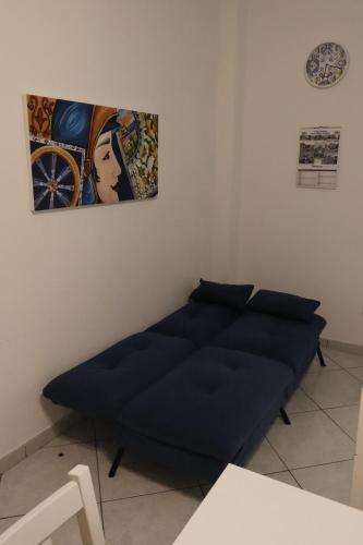 a bed in a room with a painting on the wall at Appartamenti la vuci in Partanna