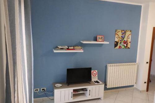 a room with a blue wall with a tv on it at Appartamenti la vuci in Partanna
