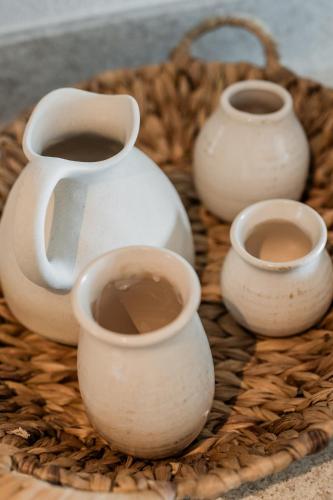 a group of white vases sitting on a basket at MAREA New 2 BDR Beachfront by Casa Paraíso in Cancún