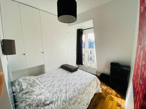 une chambre blanche avec un lit et une fenêtre dans l'établissement Turbigo, à Paris