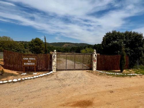 a gate with a sign in front of a field at Finca La Marquesa - Cuenca in Valera de Abajo