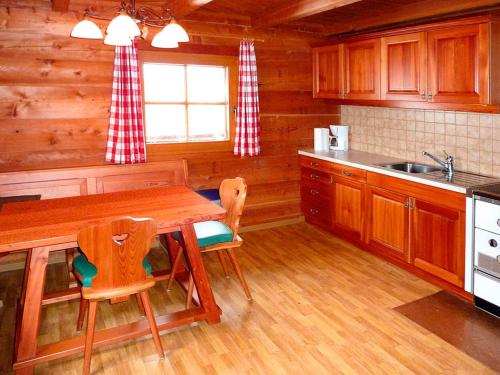 a kitchen with a table and chairs in a cabin at Almhütte Adlerhorst in Schachnern