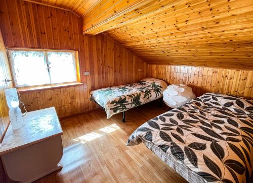 a bedroom with two beds in a wooden cabin at La casa di Leo in Folgaria