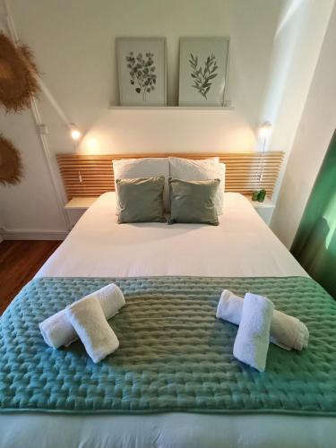 a bedroom with a bed with two towels on it at Escapade Béthunoise in Béthune
