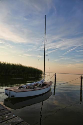 a boat sitting in the water at a dock at HAFFHUS - Hotel & Spa in Ueckermünde