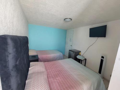 a room with two beds and a flat screen tv at Águilas Room 2 camas in Guadalajara
