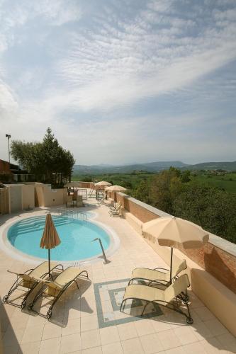 a swimming pool with two chairs and an umbrella at Casa Oliva borgo del Benessere Olistico in Bargni