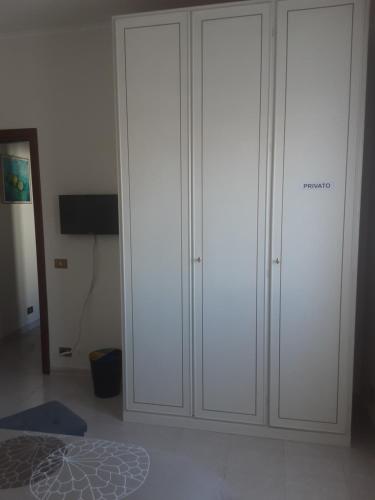 two white cabinets in a room with a bed at B&B Il viaggio in Borghesiana 