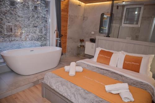 a bathroom with two beds and a bath tub at Bujtina Miqesia in Theth