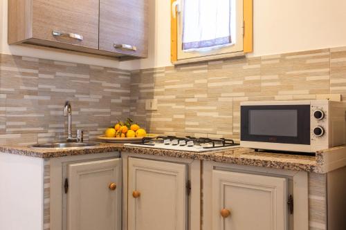 a kitchen with a stove and a microwave on a counter at Mondello House Eraclea in Mondello