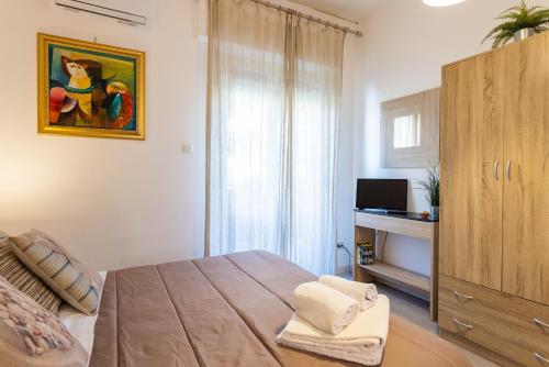 a bedroom with a bed and a cabinet and a television at Mondello House Eraclea in Mondello