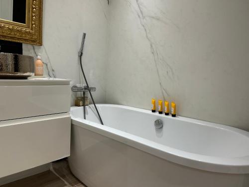 La salle de bains blanche est pourvue d'une baignoire blanche. dans l'établissement Mermoz Luxury Suite, à Marseille
