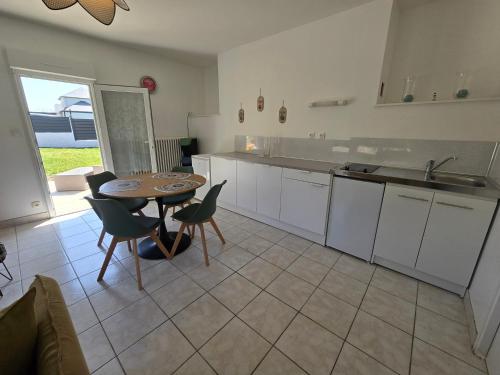 - une cuisine avec une table, une table et des chaises dans l'établissement Maison rénovée avec jardin - Calme et confort à la campagne, à Saint-Thonan