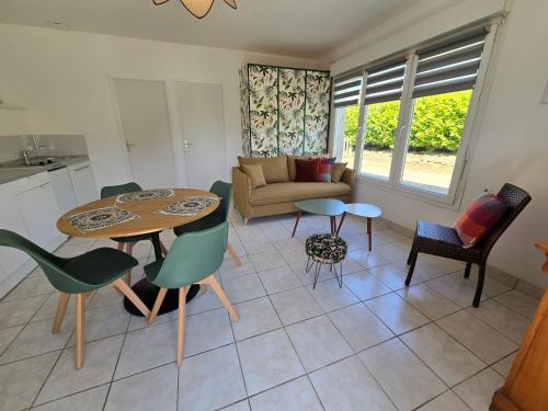 une cuisine et un salon avec une table et des chaises dans l'établissement Maison rénovée avec jardin - Calme et confort à la campagne, à Saint-Thonan