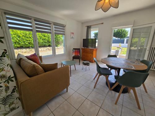 un salon avec un canapé et une table dans l'établissement Maison rénovée avec jardin - Calme et confort à la campagne, à Saint-Thonan