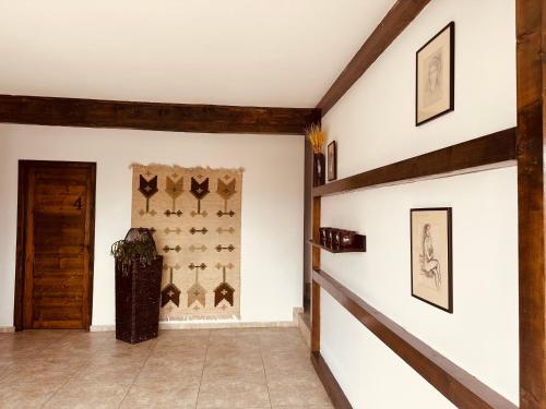 a hallway with white walls and wooden beams at Casa Pisica Noastra in Breaza