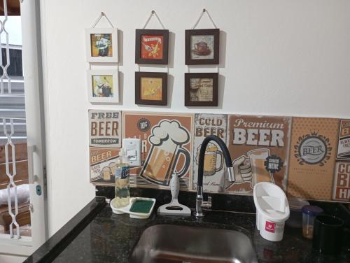 a kitchen counter with a sink and some pictures on the wall at Joia do Pepira in Brotas
