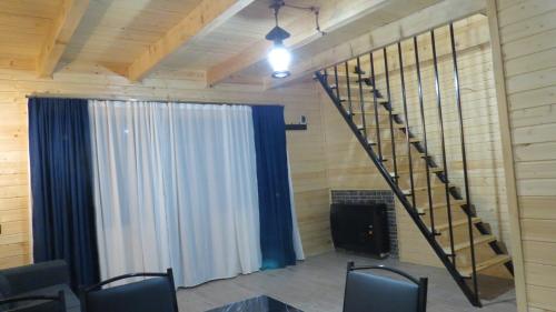a room with a staircase and a stage with chairs at Cottage nikolozi2 in Arsha