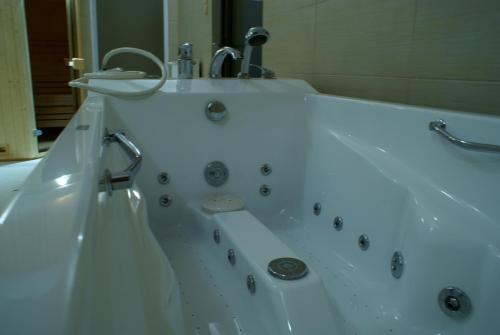 a white bath tub with a sink and a mirror at Hotel Huszcza in Mrągowo