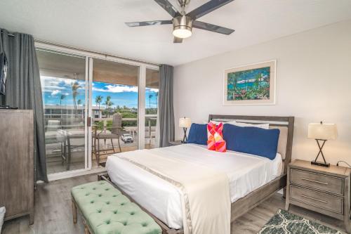 a bedroom with a bed and a balcony at Maui Banyan H506 in Wailea