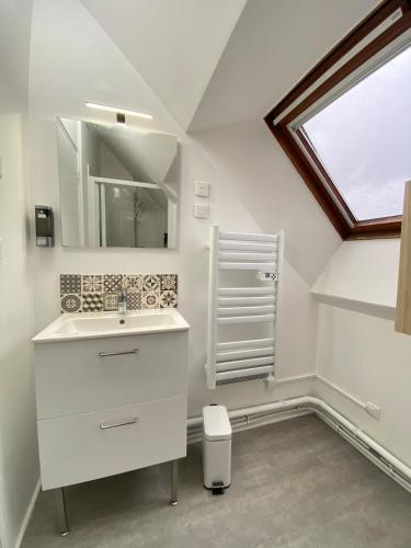 une salle de bain blanche avec un lavabo et une fenêtre dans l'établissement Jolie maison Margnotine avec cour & parking privés, à Margny-lès-Compiègne