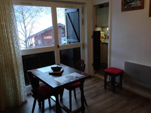 a table and chairs in a room with a window at Résidence Les Campanules - LES CAMPANULES - CA11FC MAE-3147 in Villarodin-Bourget