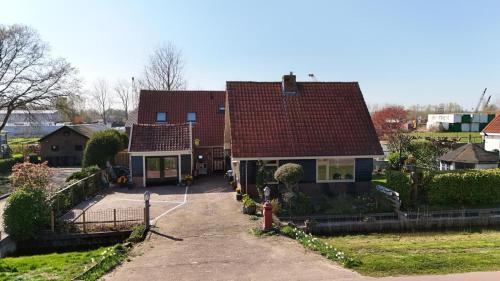 a house with a red roof and a driveway at Bed en Breakfast 1394 in Nederhorst den Berg