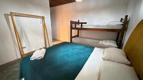 a bedroom with a bed and two bunk beds at Sambaqui Hostel in Ilhabela