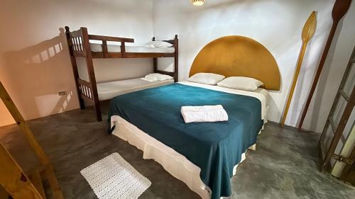 a bedroom with a bunk bed with a blue blanket at Sambaqui Hostel in Ilhabela