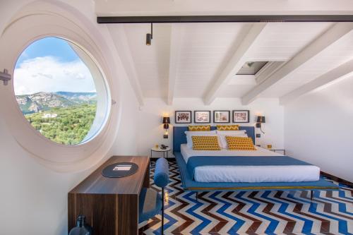a bedroom with a bed and a large window at Sorrento-luxury Suites in Colli di Fontanelle