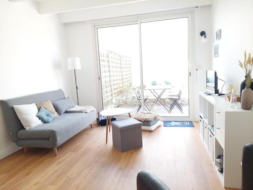 un salon avec un canapé et une table dans l'établissement L'ermitage du gué - Cocon paisible avec extérieur, à La Rochelle