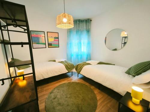 two beds in a room with a mirror at Apartamento Puerta de Madrid 2 in Alcalá de Henares