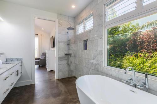 a bathroom with a bath tub and a window at Tradewinds in Princeville