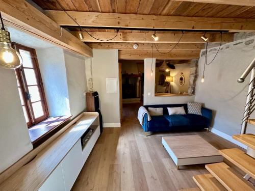 a living room with a blue couch and a table at Maison vue panoramique au Cirque de Navacelles in Blandas