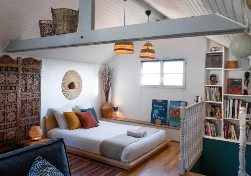 a bedroom with a bed and a book shelf at La Nuit étoilée - Maison d 'artiste - Auvers-sur-Oise in Auvers-sur-Oise