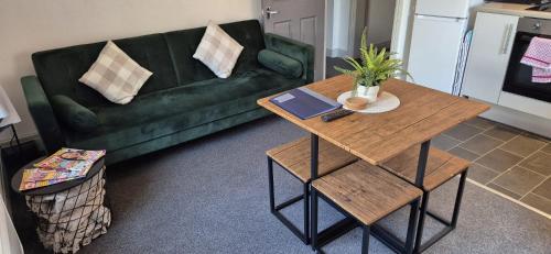 a living room with a green couch and a table at Apartment 5 in Blackpool