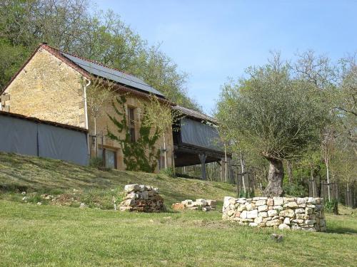 un bâtiment sur une colline avec un tas de pierres près d'un arbre dans l'établissement Studio aux Eyzies au coeur de la vallée de l'homme, à Le Repaire