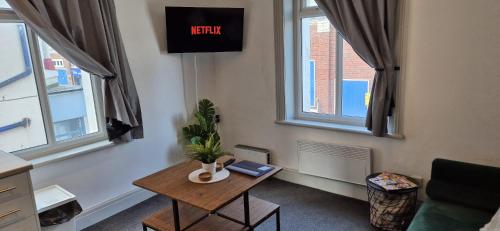 a living room with a table and two windows at Apartment 5 in Blackpool